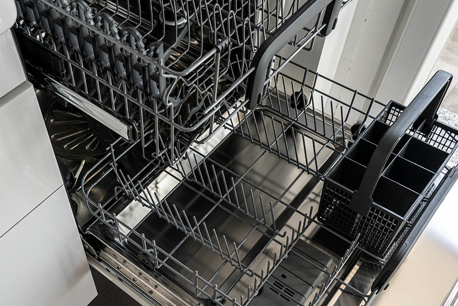 Licensed technician inspecting the drainage elevation and 3-phase power supply requirements for a heavy-duty commercial hood dishwasher.